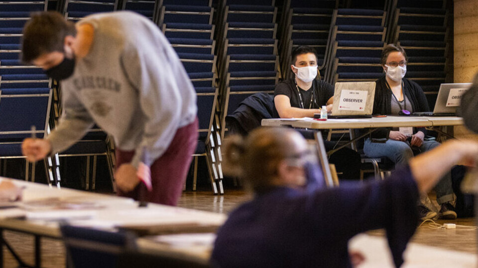 Poll workers help Nebraskan residents cast their votes on election day in a gymnasium.