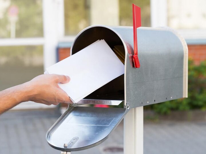 Hand putting envelope in mailbox